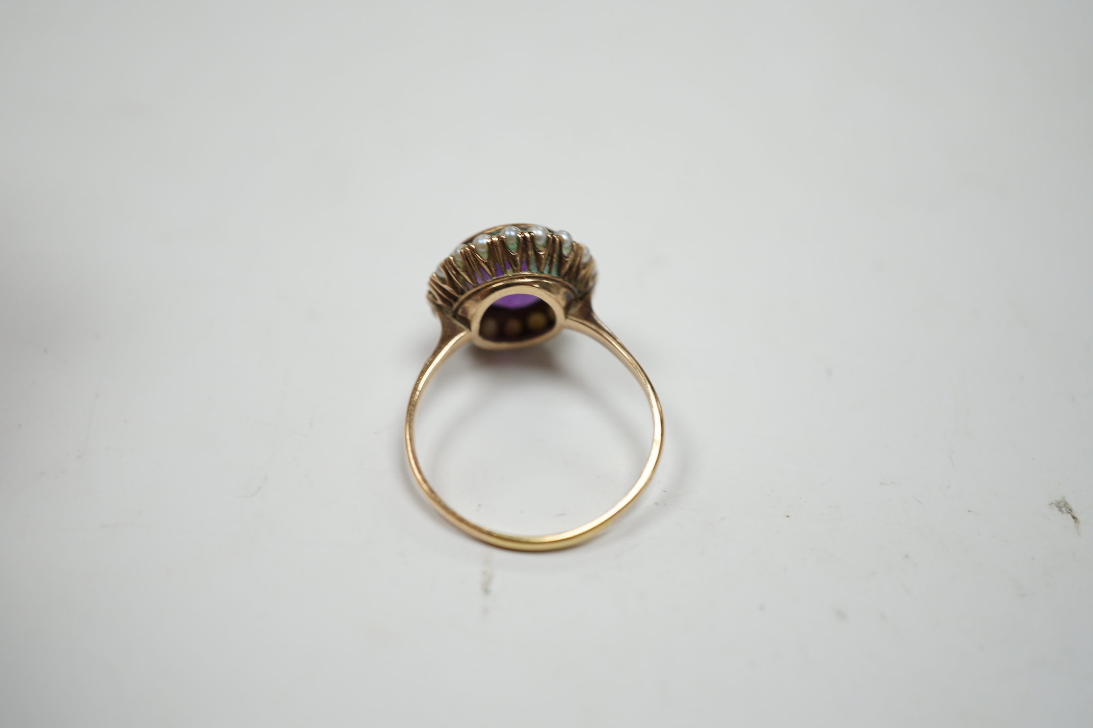 A mid 20th century 14k yellow metal, amethyst and seed pearl set circular cluster ring, size U/V, gross weight 4.3 grams.